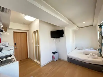 a small room with a bed and a kitchen at Skytree\u8eca\u7ad95\u5206 3\u5957\u885b\u6d74 \u6709\u96fb\u68af \u8868\u53c3\u9053 \u6a5f\u5834\u76f4\u9054 \u5eda\u623f \u6d17\u8863\u6a5f \u81ea\u52a9\u5f0f\u5165\u4f4f \u96fb\u68af 644 in Tokyo
