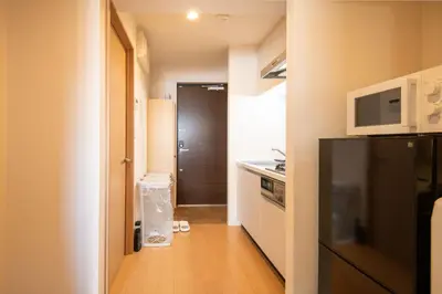 a kitchen with a black refrigerator and a microwave at Elle Maison\u5927\u68ee 203 in Tokyo