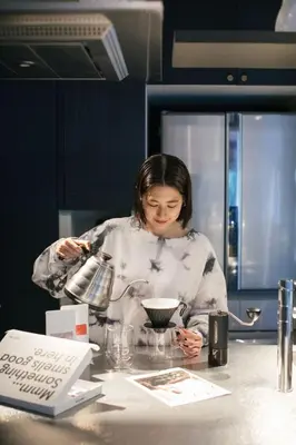 a woman standing at a counter with a mixing bowl at Aoyama Roppongi Fully renovated Japanese house in Tokyo