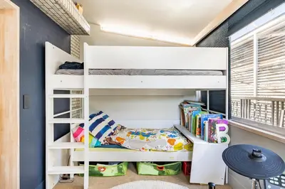 a bedroom with a white bunk bed and books at Aoyama Roppongi Fully renovated Japanese house in Tokyo