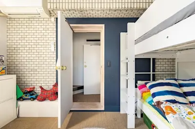 a bedroom with white bunk beds and a brick wall at Aoyama Roppongi Fully renovated Japanese house in Tokyo
