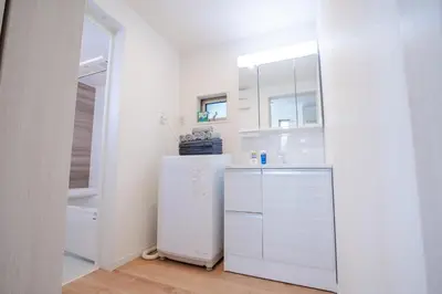 a white kitchen with a refrigerator in a room at \u65b0\u5bbf \u6d89\u8c37 \u539f\u5bbf\u53ef\u591a\u7ebf\u76f4\u8fbe \u6709Wifi \u5c71\u624b\u7ebf\u5927\u7ad9\u6c60\u888b\u8f66\u7ad9\u4e00\u6238\u5efa in Tokyo