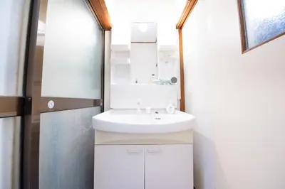 a bathroom with a white sink and a mirror at Shōwamachi 3bedrooms KI0325 in Tokyo