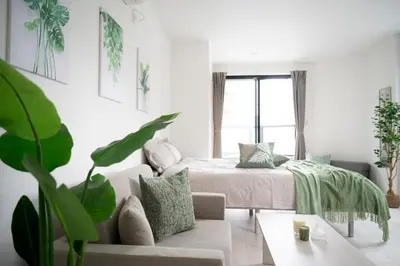 a white bedroom with a bed and a couch at CASA201 1-minute walk from the station, Asakusa, Akihabara, Ginza, Tsukiji, Toyosu, Shinjuku, Shibuya, Narita, Haneda, good access in Tokyo