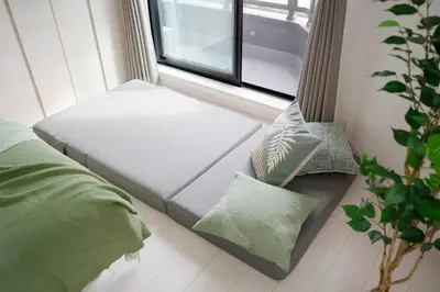 a window seat in a bedroom with green pillows at CASA201 1-minute walk from the station, Asakusa, Akihabara, Ginza, Tsukiji, Toyosu, Shinjuku, Shibuya, Narita, Haneda, good access in Tokyo