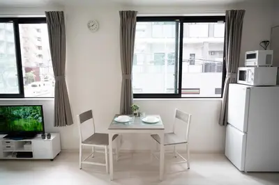 a kitchen with a table and chairs and a refrigerator at CASA201 1-minute walk from the station, Asakusa, Akihabara, Ginza, Tsukiji, Toyosu, Shinjuku, Shibuya, Narita, Haneda, good access in Tokyo
