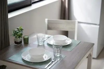 a wooden table with plates and glasses on it at CASA201 1-minute walk from the station, Asakusa, Akihabara, Ginza, Tsukiji, Toyosu, Shinjuku, Shibuya, Narita, Haneda, good access in Tokyo