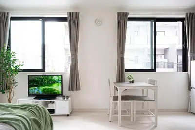 a bedroom with a desk and a tv and windows at CASA201 1-minute walk from the station, Asakusa, Akihabara, Ginza, Tsukiji, Toyosu, Shinjuku, Shibuya, Narita, Haneda, good access in Tokyo