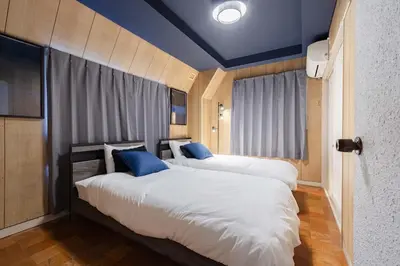 two beds in a hotel room with blue ceilings at LINKAGE STAY Chitose Funabashi in Tokyo