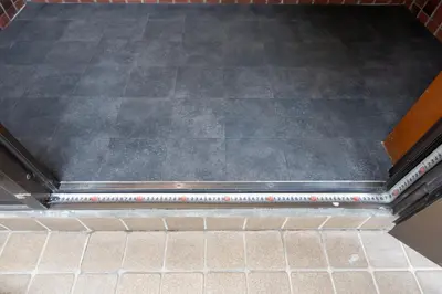 a table with a black top on a tile floor at Kstyle Apartments KURI in Tokyo