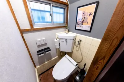a small bathroom with a toilet and a window at Kstyle Apartments KURI in Tokyo