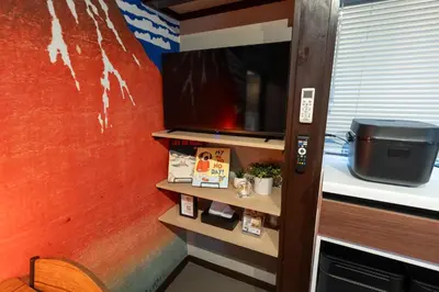 a room with a tv and a shelf at Kstyle Apartments KURI in Tokyo