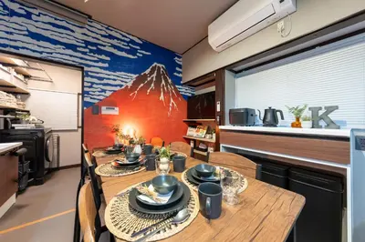 a dining room with a mountain mural on the wall at Kstyle Apartments KURI in Tokyo