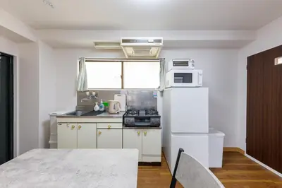 a kitchen with a white refrigerator and a microwave at \u306a\u306a\u5bbf \u6d45\u8349\u4e09\u30ce\u8f2a in Tokyo