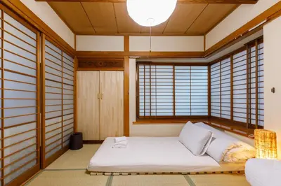 a room with a bed in a room with windows at \u306a\u306a\u5bbf \u6d45\u8349\u4e09\u30ce\u8f2a in Tokyo