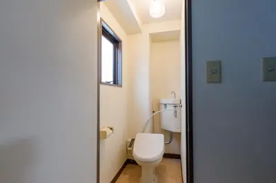 a small bathroom with a toilet and a window at \u306a\u306a\u5bbf \u6d45\u8349\u4e09\u30ce\u8f2a in Tokyo