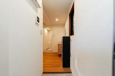 a hallway with white walls and a black refrigerator at Promotion Itabashi , 1 room, Max 4P \u8d85\u9ad8\u6027\u4ef7\u6bd4 \u677f\u6865\u5168\u65b0\u88c5\u4fee \u8bbe\u5907\u9f50\u5168 \u65e0\u7ebf\u7f51\u7edc \u6700\u59274\u4eba in Tokyo