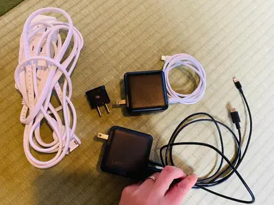 a person holding a cell phone next to a pile of wires at \u5927\u798f\u30cf\u30a6\u30b92 in Tokyo