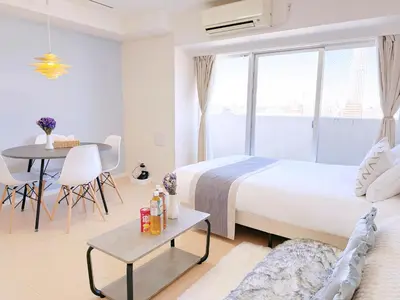 a white bedroom with a bed and a table and a tableablish at Bright Skytree View Apartment,6 Min Walk to Kinshicho Station in Tokyo