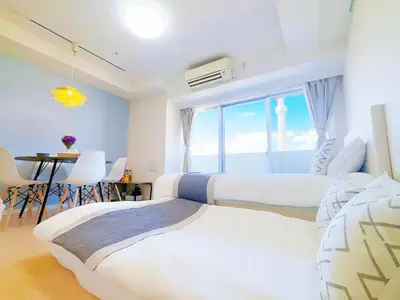 a bedroom with two beds and a table and a window at Bright Skytree View Apartment,6 Min Walk to Kinshicho Station in Tokyo