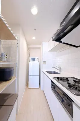 a white kitchen with a stove and a refrigerator at Bright Skytree View Apartment,6 Min Walk to Kinshicho Station in Tokyo