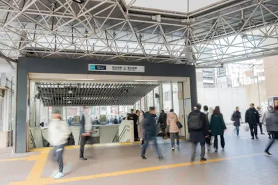 a group of people walking in a building at unito residence EBISU STATION North in Tokyo
