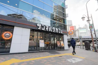 a man walking in front of a store at unito residence EBISU STATION North in Tokyo