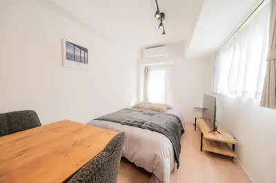 a bedroom with a bed and a wooden table at unito residence EBISU STATION North in Tokyo