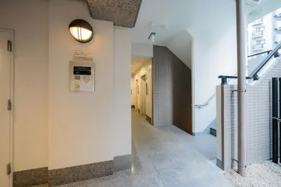a hallway in a building with a light on the wall at unito residence EBISU STATION North in Tokyo