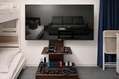 a living room with a couch and a tv on the wall at GrAce Room IKEBUKURO in Tokyo