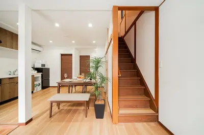 a kitchen and dining room with a staircase in a house at NISHIKI Ryokan\u9326\u65c5\u9928 in Tokyo