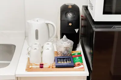 a kitchen counter with a coffee maker and a microwave at NISHIKI Ryokan\u9326\u65c5\u9928 in Tokyo