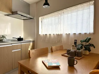 a kitchen with a wooden table in a kitchen with a window at TOKYO AKATSUKI HOTEL - asakusa \u3042\u304b\u3064\u304d\u30db\u30c6\u30eb\u3042\u3055\u304f\u3055 in Tokyo