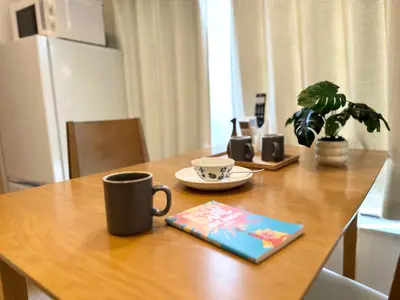 a table with a coffee cup and a book on it at TOKYO AKATSUKI HOTEL - asakusa \u3042\u304b\u3064\u304d\u30db\u30c6\u30eb\u3042\u3055\u304f\u3055 in Tokyo
