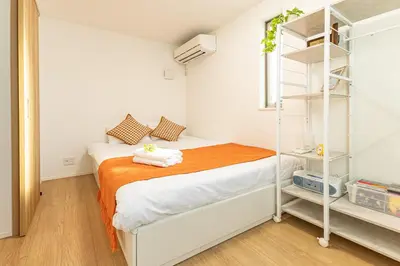 a bedroom with a bed with an orange blanket at Oshiage 3-chome Entire House Near Skytree in Tokyo