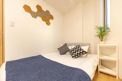 a bedroom with a bed and a plant on the wall at Oshiage 3-chome Entire House Near Skytree in Tokyo