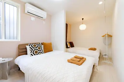 two beds in a small room with white walls at \u30a2\u30f3\u30c9\u30b9\u30c6\u30a4\u5343\u4f4f\u4ef2\u753aa in Tokyo