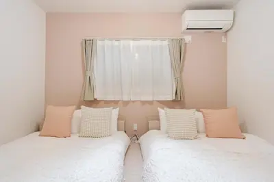two beds in a room with a window at \u30a2\u30f3\u30c9\u30b9\u30c6\u30a4\u5343\u4f4f\u4ef2\u753aa in Tokyo