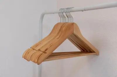 a wooden triangle sign hanging on a wall at \u30a2\u30f3\u30c9\u30b9\u30c6\u30a4\u5343\u4f4f\u4ef2\u753aa in Tokyo