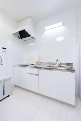 a white kitchen with white cabinets and a sink at \u30a2\u30f3\u30c9\u30b9\u30c6\u30a4\u5343\u4f4f\u4ef2\u753ab in Tokyo