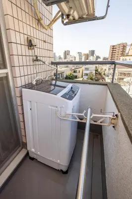 a washing machine sitting on the side of a balcony at 8 min to Ikebukuro, 6 min walk from Yomachi Station, Max 2 people, Straight to Tokyo, Shinjuku, Shibuya, Ueno 302 in Tokyo