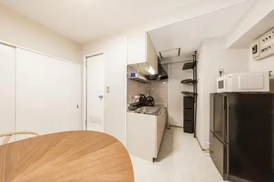 a kitchen with a table and a refrigerator at 8 min to Ikebukuro, 6 min walk from Yomachi Station, Max 2 people, Straight to Tokyo, Shinjuku, Shibuya, Ueno 302 in Tokyo