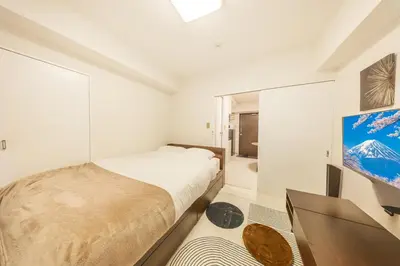 a bedroom with a bed and a television in it at 8 min to Ikebukuro, 6 min walk from Yomachi Station, Max 2 people, Straight to Tokyo, Shinjuku, Shibuya, Ueno 302 in Tokyo