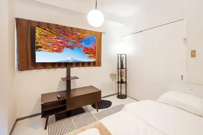 a bedroom with a bed and a tv on the wall at 8 minutes on foot from Ikebukuro, 6 minutes on foot from Kanamecho Station, Maximum 2 people, Direct to Tokyo, Shinjuku, Shibuya, Ueno 102 in Tokyo