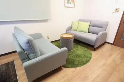 a living room with two chairs and a green rug at \u8c4a\u6d32\u671d\u51ea\u306e\u5bbf in Tokyo