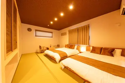 a bedroom with two beds and a window at Seven's Inn Takaramachi in Tokyo