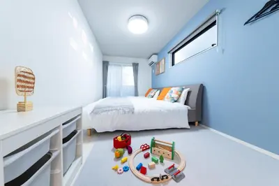 a bedroom with blue walls and a bed and a table at Seven's Inn Takaramachi in Tokyo