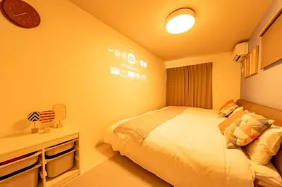 a bedroom with a bed and a clock on the wall at Seven's Inn Takaramachi in Tokyo