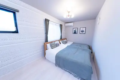 a white bedroom with a bed and a window at Seven's Inn Takaramachi in Tokyo