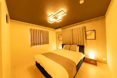a bedroom with a bed and a chandelier at Seven's Inn Takaramachi in Tokyo